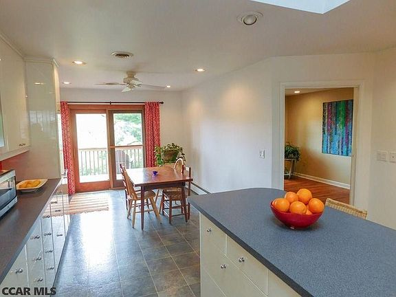 Kitchen backs up to porch across back of house, overlooking wooded yard.