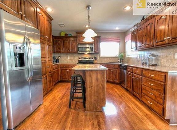 Kitchen features stainless steel appliances, granite & wood floors