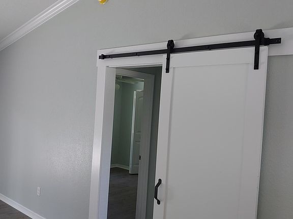 Barn door leads to 2 bedrooms and bathroom.