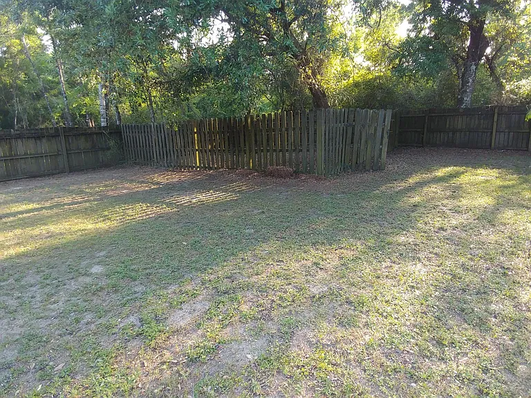 Left side of back yard with additional fenced pen