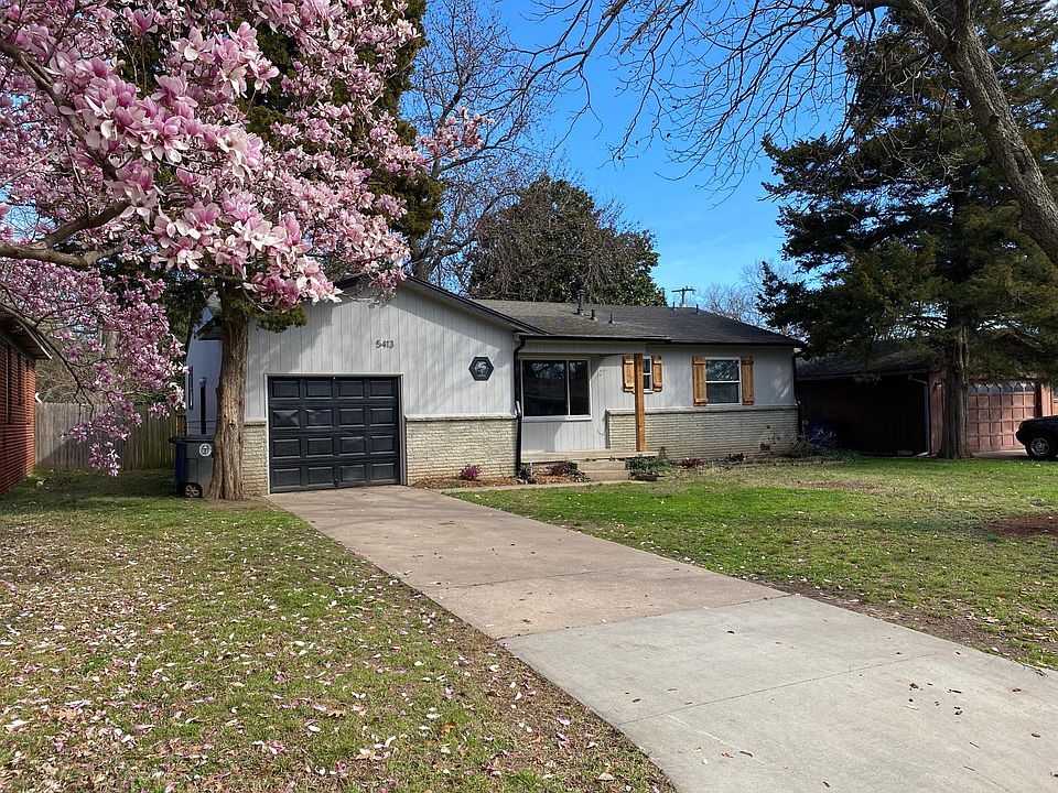 New garage door and gutters. Pecan tree in front and cherry tree in neighbors yard that blooms in the spring.