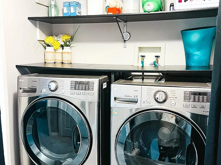 Upper level laundry with large front loaders and shelving.
