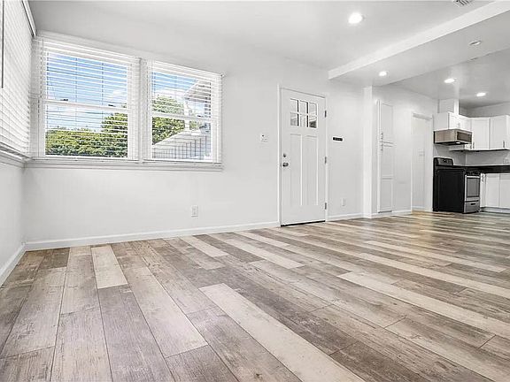 Bright and spacious living room with recessed lights, luxury vinyl plank flooring and more