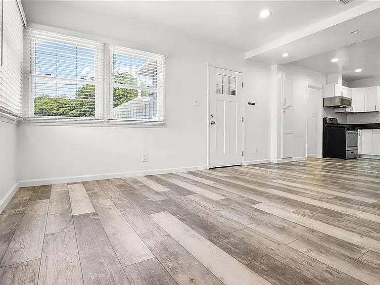 Bright and spacious living room with recessed lights, luxury vinyl plank flooring and more