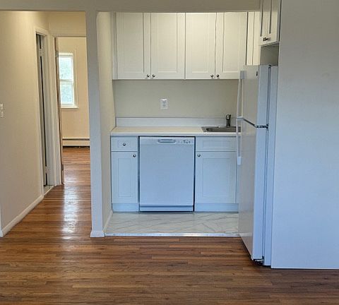 Renovated kitchen with new dishwasher, refrigerator, stove and cabinets. Hallway to bathroom, bedroom.