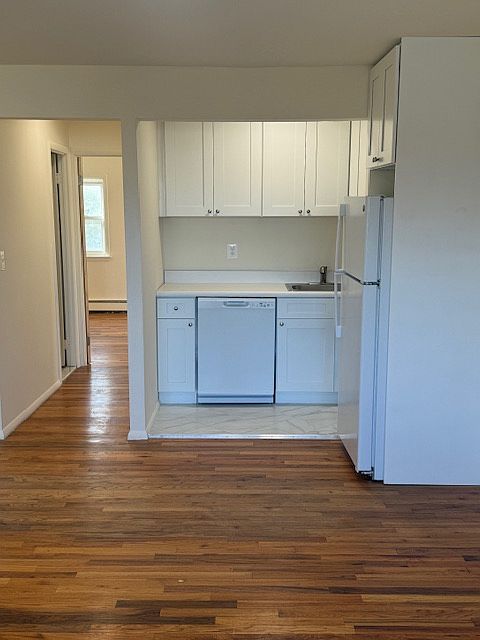 Renovated kitchen with new dishwasher, refrigerator, stove and cabinets. Hallway to bathroom, bedroom.