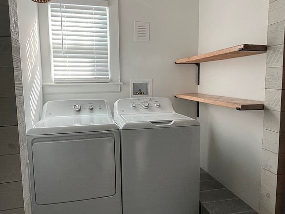 Laundry Room off of the Kitchen with matching rustic shelves. The large custom gliding Barn-door conceals this room that is located off of the Kitchen.