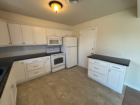 Kitchen, refrigerator included, door leading into garage