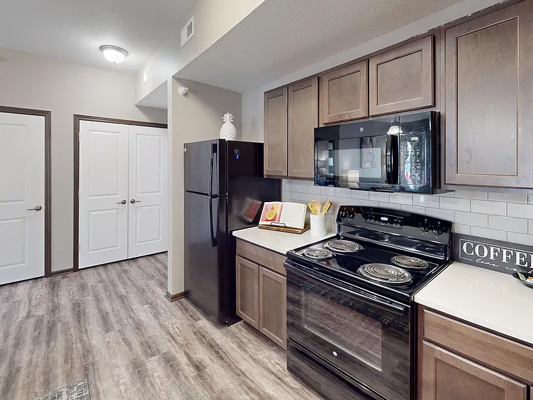 Subway tile, custom cabinetry, a dishwasher, and microwave are all kitchen features.