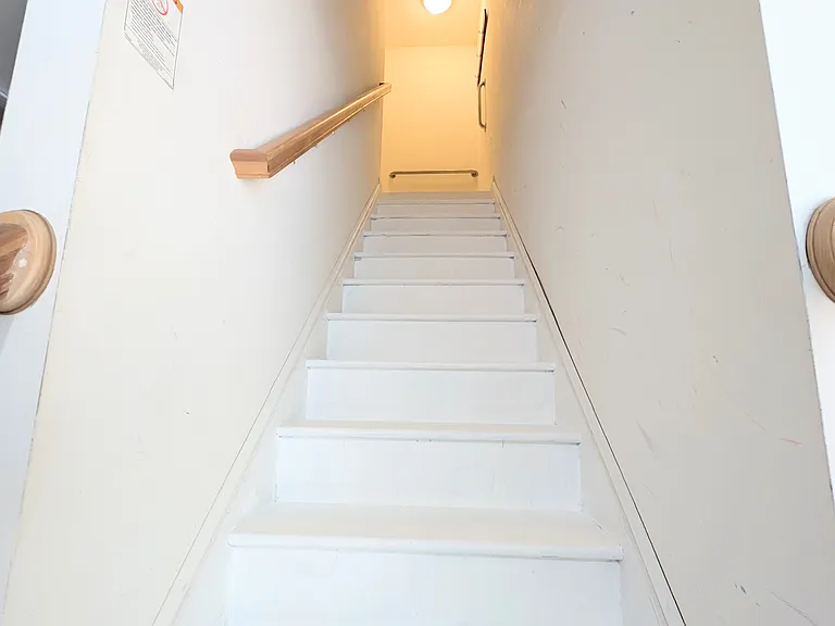 Stairs inside garage that lead to upstairs unit