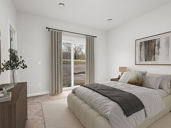 The master bedroom is spacious enough to fit a large bed and side tables.