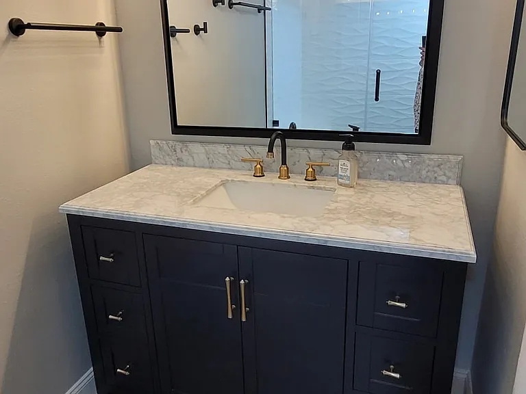 Primary bathroom vanity with custom lighting and full sized mirror.