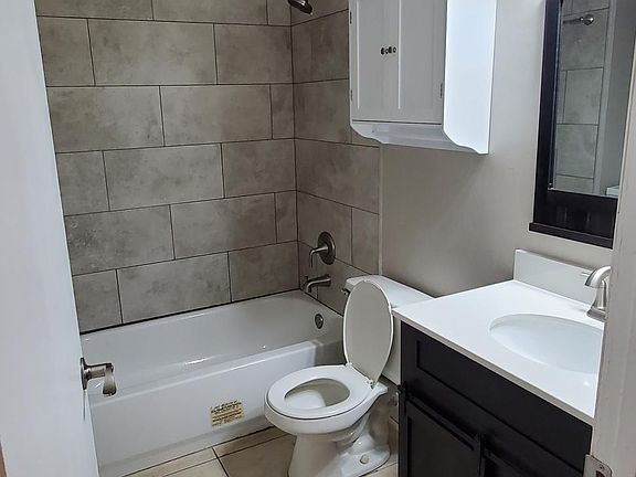 Bathroom # 2. New vanity, new cabinets, new lighting. New tile around tub.