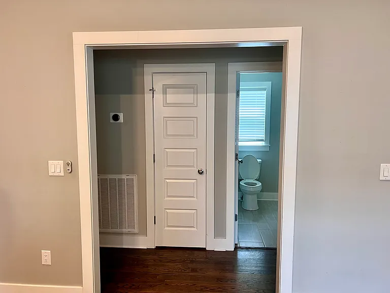 Living room looking to hallway to guest bathroom and two bedrooms