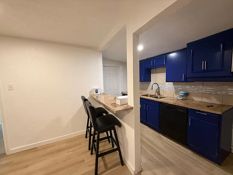 Kitchen features a breakfast bar with seating, ample cabinetry, and a full sink area for easy meal prep and cleanup.