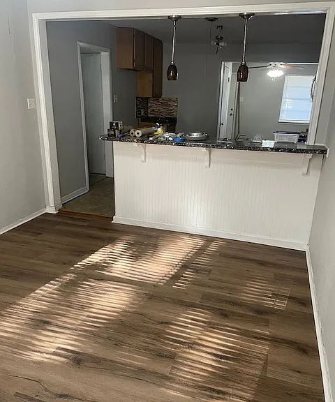 **updated photos coming soon** New Flooring and fresh paint, this is the the view from the dining room to the kitchen- with the font living room area in the background.