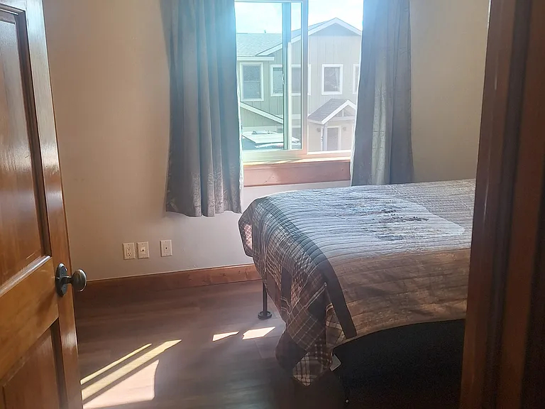 Middle bedroom full size bed and window from hallway.