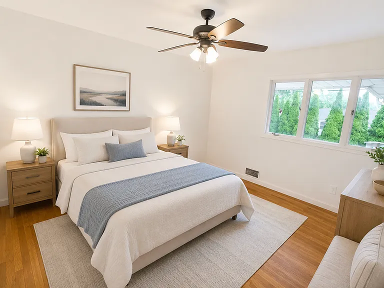 Bedroom #6 features a beautiful triple window that fills the space with natural sunlight and brings in peaceful views of the surrounding greenery