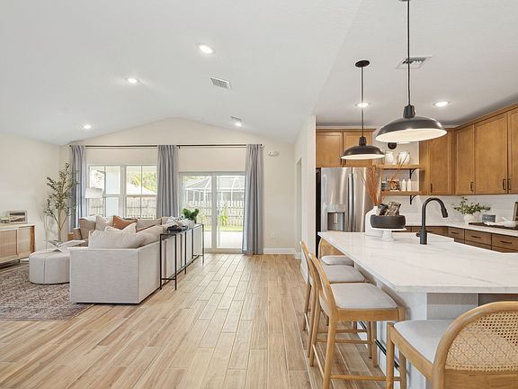 Kitchen overlooking great room and dining area with vaulted ceiling
