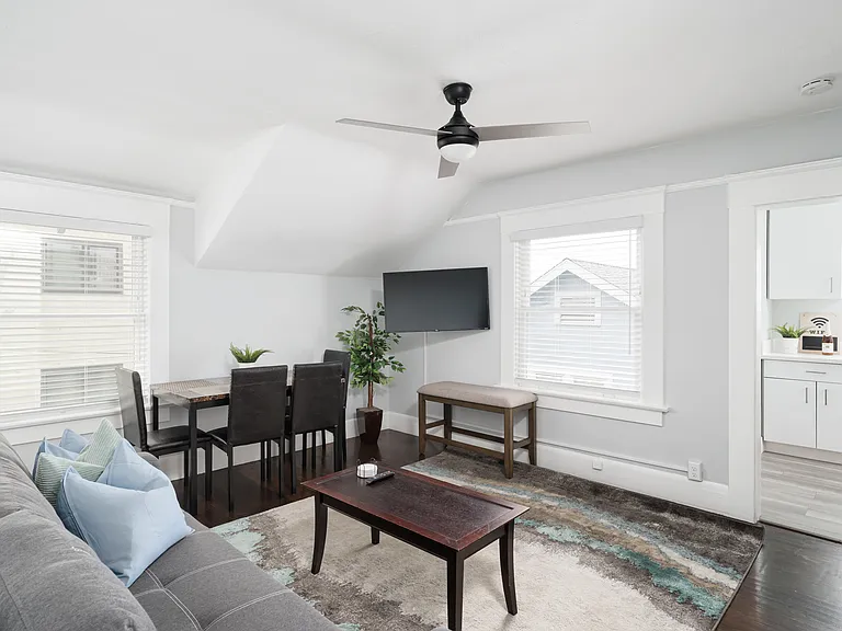 Living room and dining space with seating for four. Smart TV includes subscriptions to Hulu, Disney+ and ESPN+.