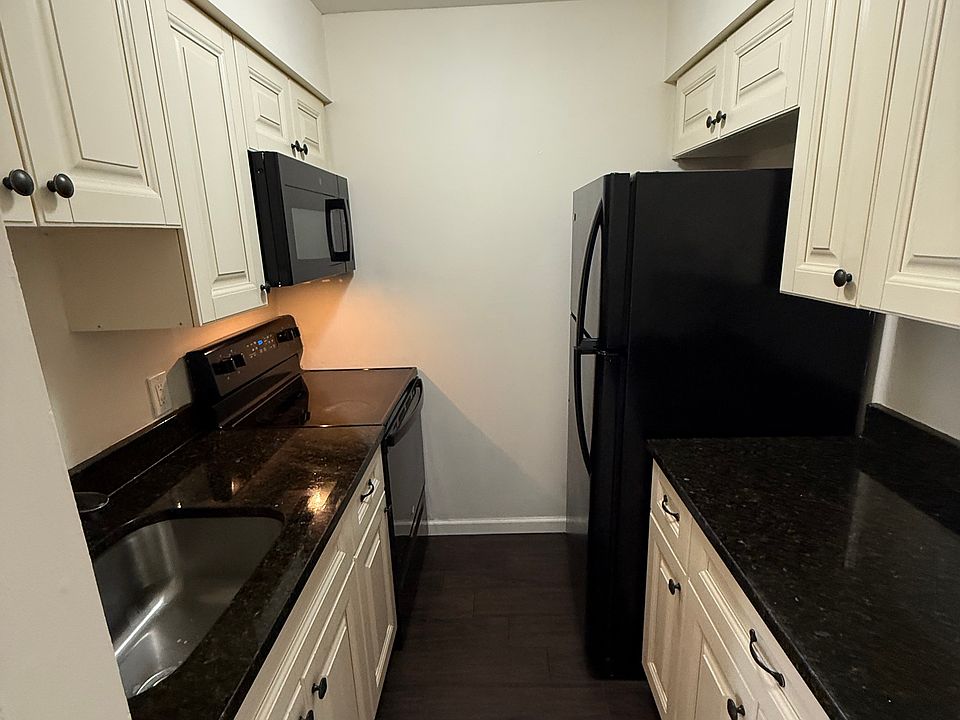 Kitchen with granite countertops, full size oven, refrigerator and microwave.