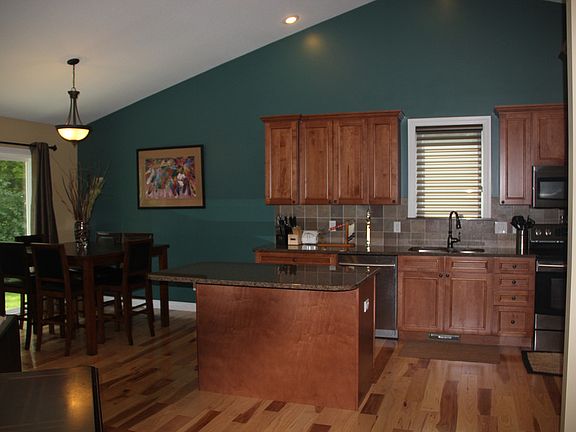 Step into the gorgeous cherry kitchen with vaulted ceilings, granite counters and hickory flooring.