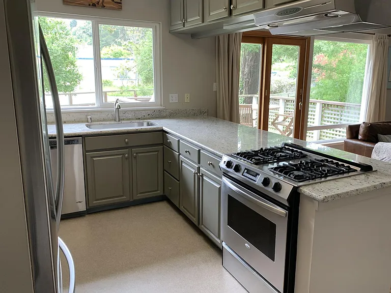Open kitchen with gas range, stainless appliances, breakfast bar