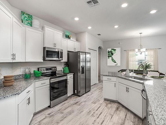 The open kitchen includes a counter-height island and ample cabinet and counter space - Willow II by