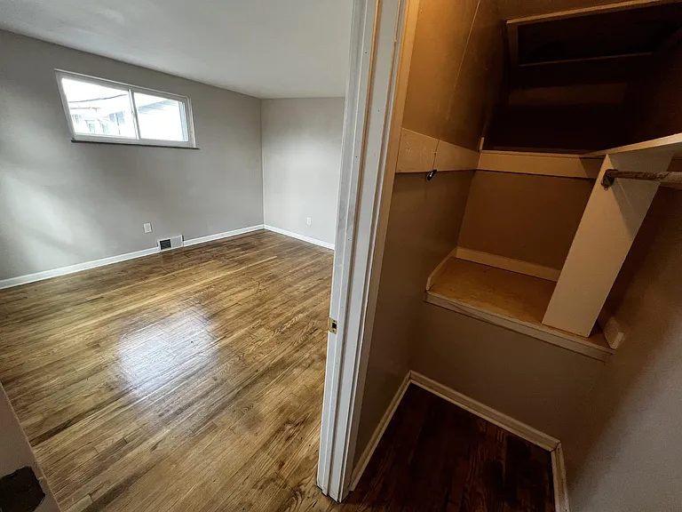 Front bedroom with walk-in closet and refinished hardwood floors