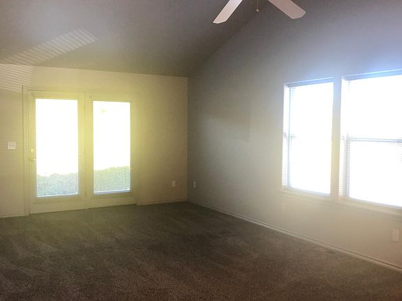 Living room with vaulted ceiling, windows catch the morning sun
