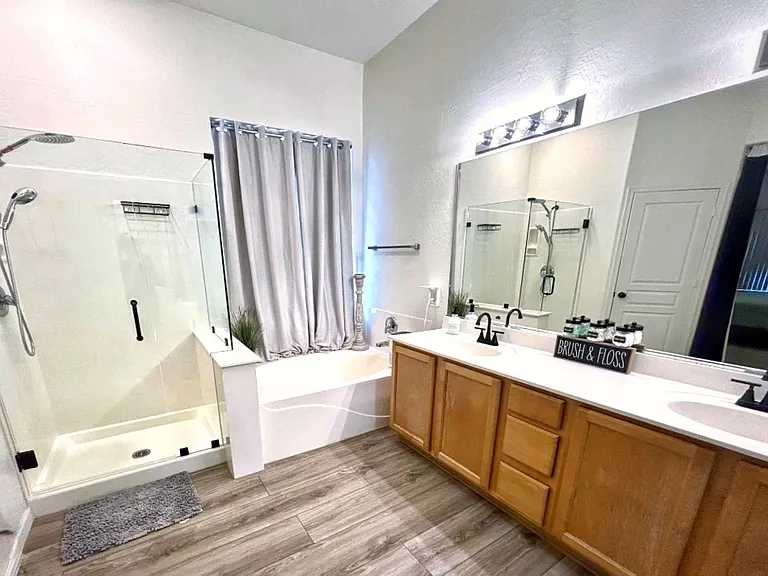 Large primary bathroom connected to primary bedroom. Includes large bathtub for relaxing, walk-in shower with new shower glass and removable shower head, 2 sink vanity with ample storage, toilet room with door for privacy.