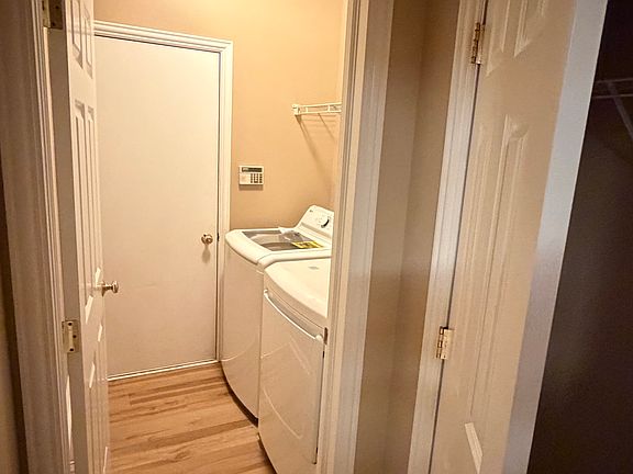 Laundry with new washer, dryer (both 2026) and exit to the garage. Adjacent coat closet.