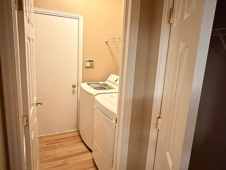 Laundry with new washer, dryer (both 2026) and exit to the garage. Adjacent coat closet.