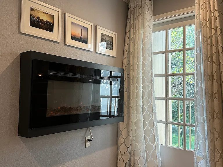 Electric fireplace and patio in primary bedroom.