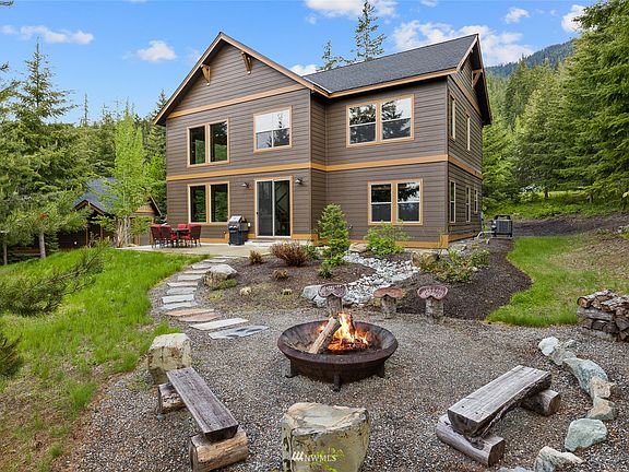View of the back of the home. This stunning home has an upper patio & a lower patio with a wood fire pit. 