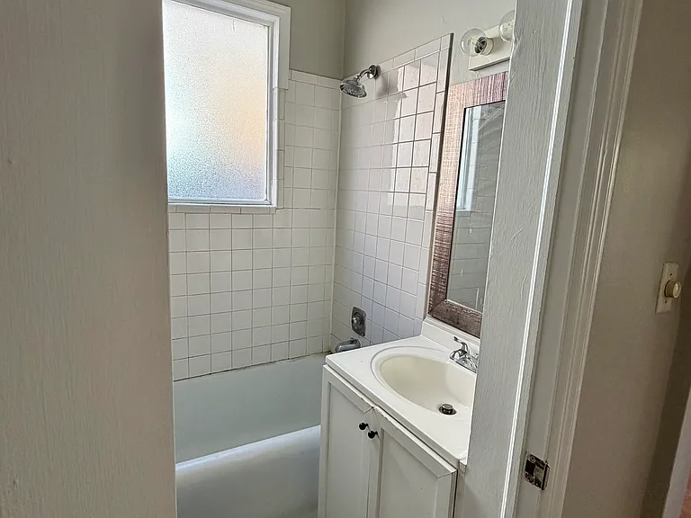3 piece bathroom with cast iron bathtub/shower, sink and toilet.