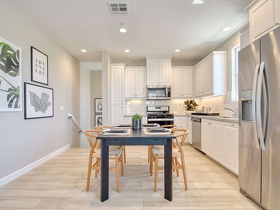 An image of the kitchen and dining space in the Citrus Plan 1 Model Home at New Haven.