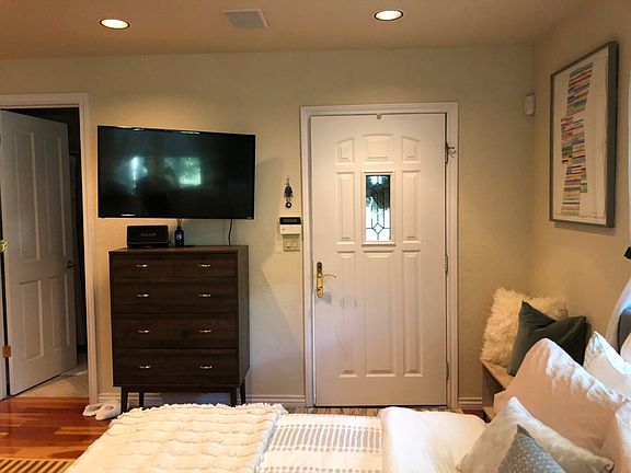View from corner showing Entry door, Wall Mount TV, and doorway to bathroom