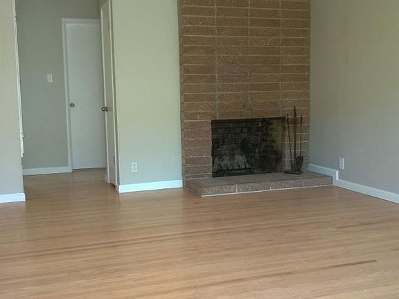 Living room with refinished hardwood floors and wood-burning