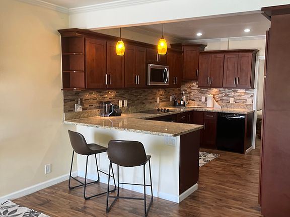 Modern kitchen with stylish cabinetry, stainless steel appliances, and a breakfast bar. Perfect for all your culinary needs and entertaining guests.