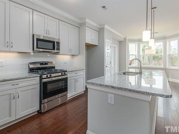 Open kitchen with breakfast bar and dining room at the end.