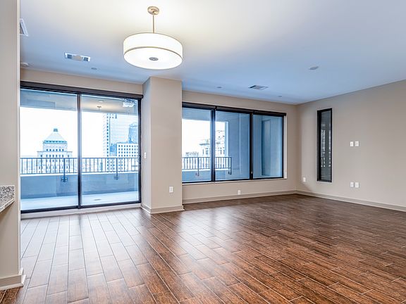 Step into modern elegance at AT580 Apartments. This spacious living area is filled with natural light, featuring stunning wood floors and large windows that open to breathtaking views. Ideal for relaxation and entertainment. Schedule your tour today!