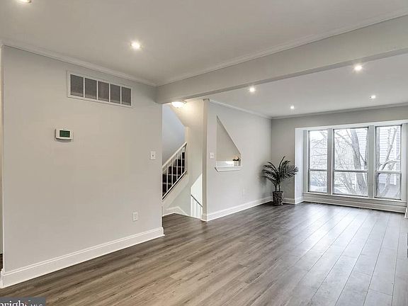 REPRESENTATIVE SAMPLE DUE TO RENOVATION - Luxury plank flooring in a light french oak tone installed throughout entire home. Sherwin Williams Moderne White freshly painted throughout townhouse. Brand new windows installed. This is the family room and d