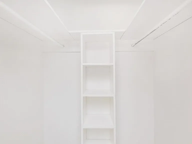 Spacious walk-in closet with built-in shelving for organized and easy storage.