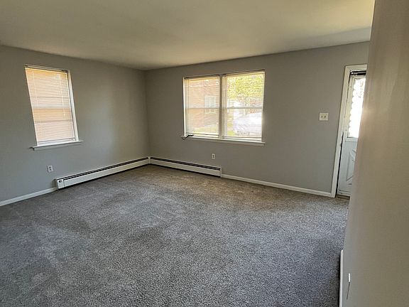 Looking into living room from rear of unit. Front door visible.