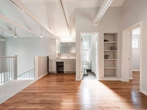 Bath, vanity to left and shelving to right. Closet door at extreme right.