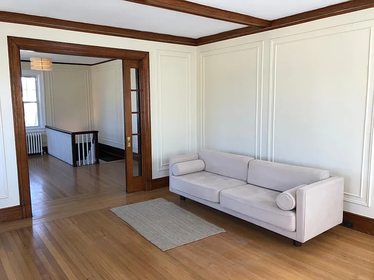 Living room (unfurnished) looking to entry/dining area. This area near the stairs can also be used as office space. Rooms are large and the ceilings are about 9ft.
