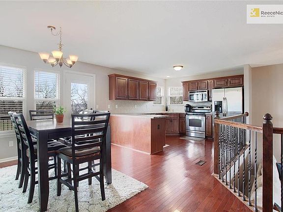The kitchen/dining combo features wood floors and stainless appliances.  A pantry exists at the top of the stairs and the door leads to a deck -- the perfect place to enjoy a warm spring evening.