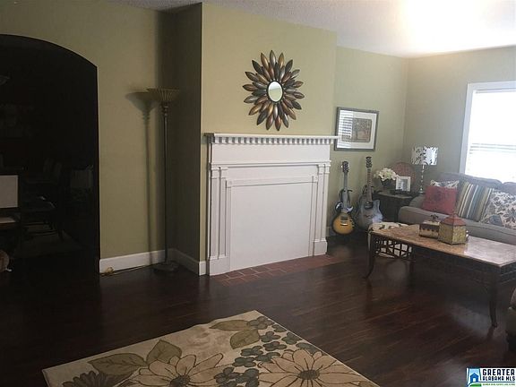 Image 4: Current owners covered the fireplace - seller says it could be uncovered and made into a working fireplace .