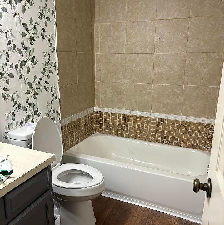 Main bath, new flooring, new toilet and wall paper